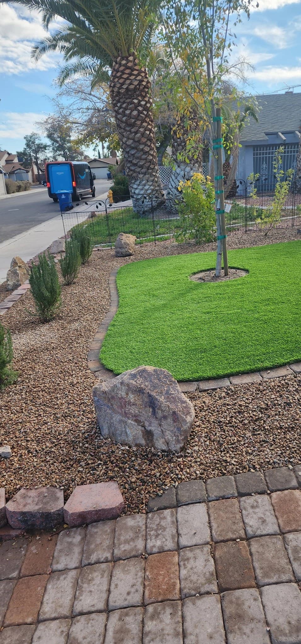 Front-yard desert landscape design with artificial turf, decorative rock, and a new tree in Las Vegas