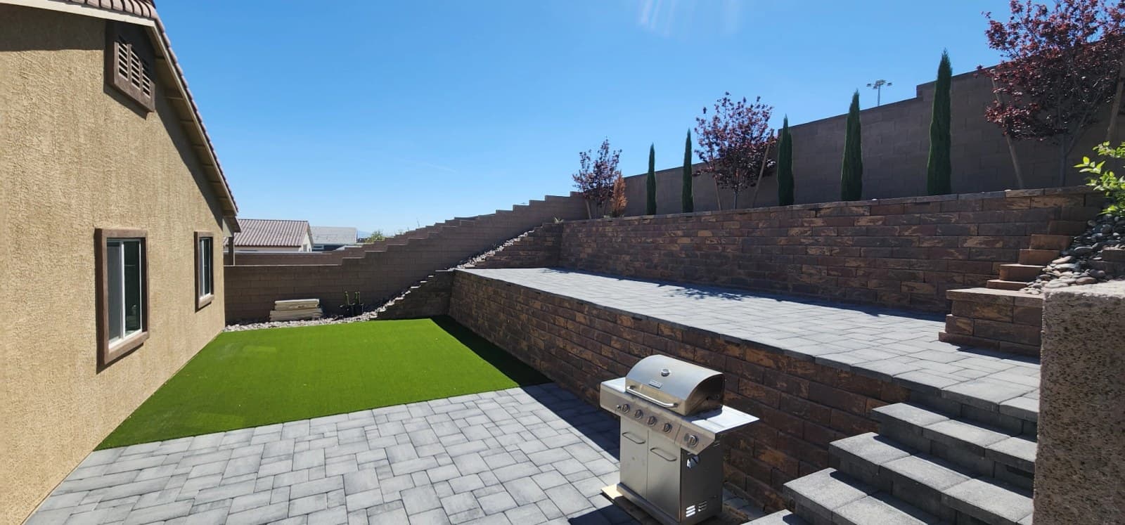 Backyard transformation with pavers, retaining walls, and turf in Las Vegas